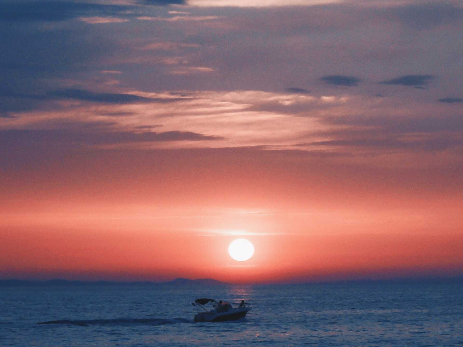 Picture of a boat at sea at sunset